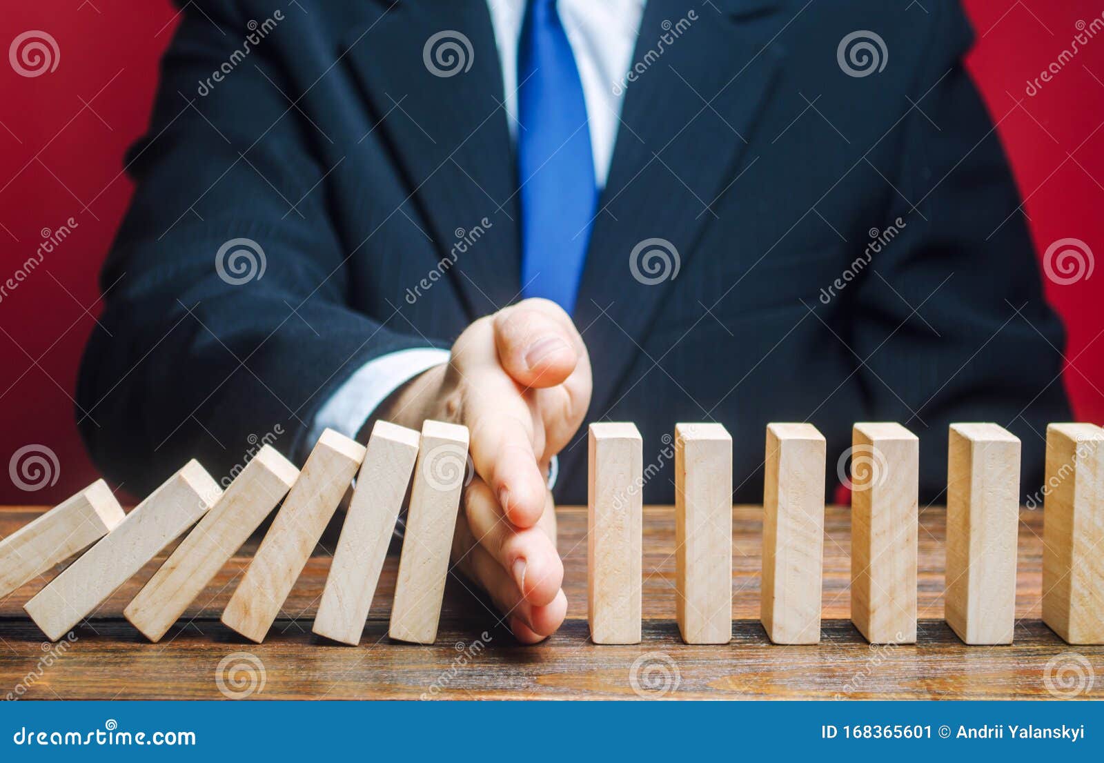 businessman stops domino falling. risk management concept. successful strong business and problem solving. reliable leader. stop