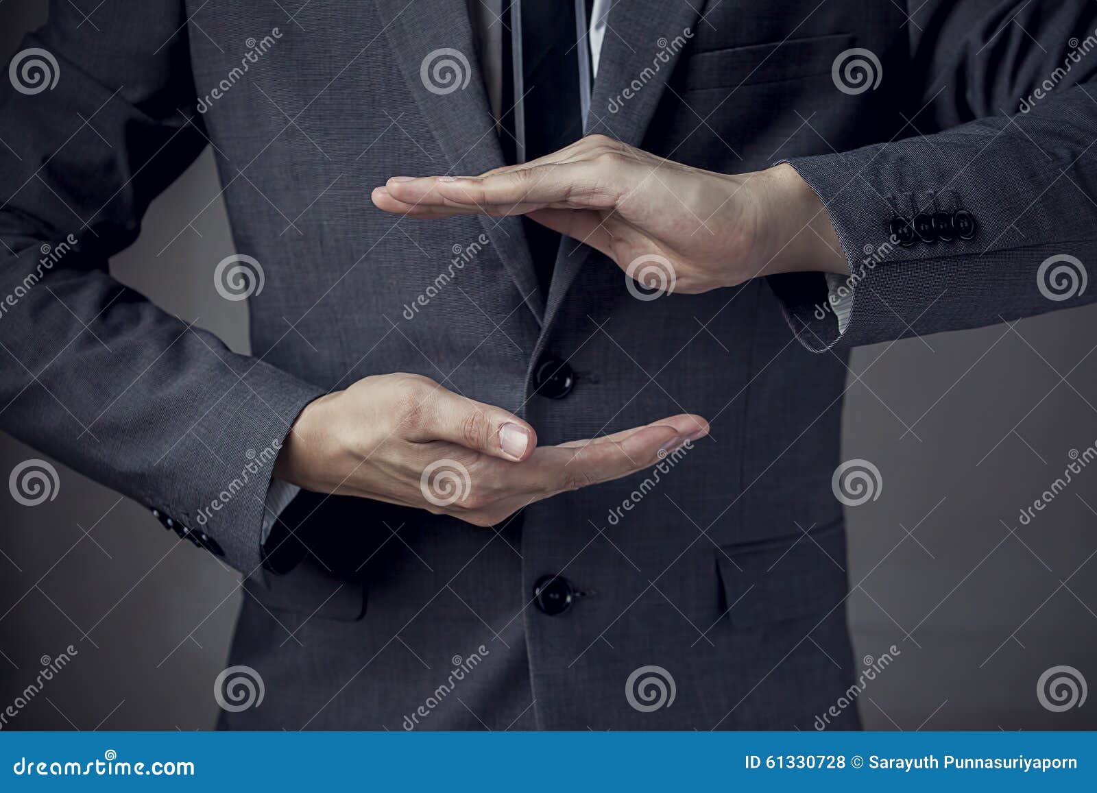 businessman in suit with two hands in position to protect something