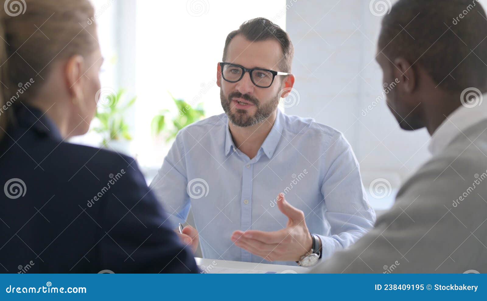 Businessman Talking To Mixed Race Business People in Office Stock Image ...