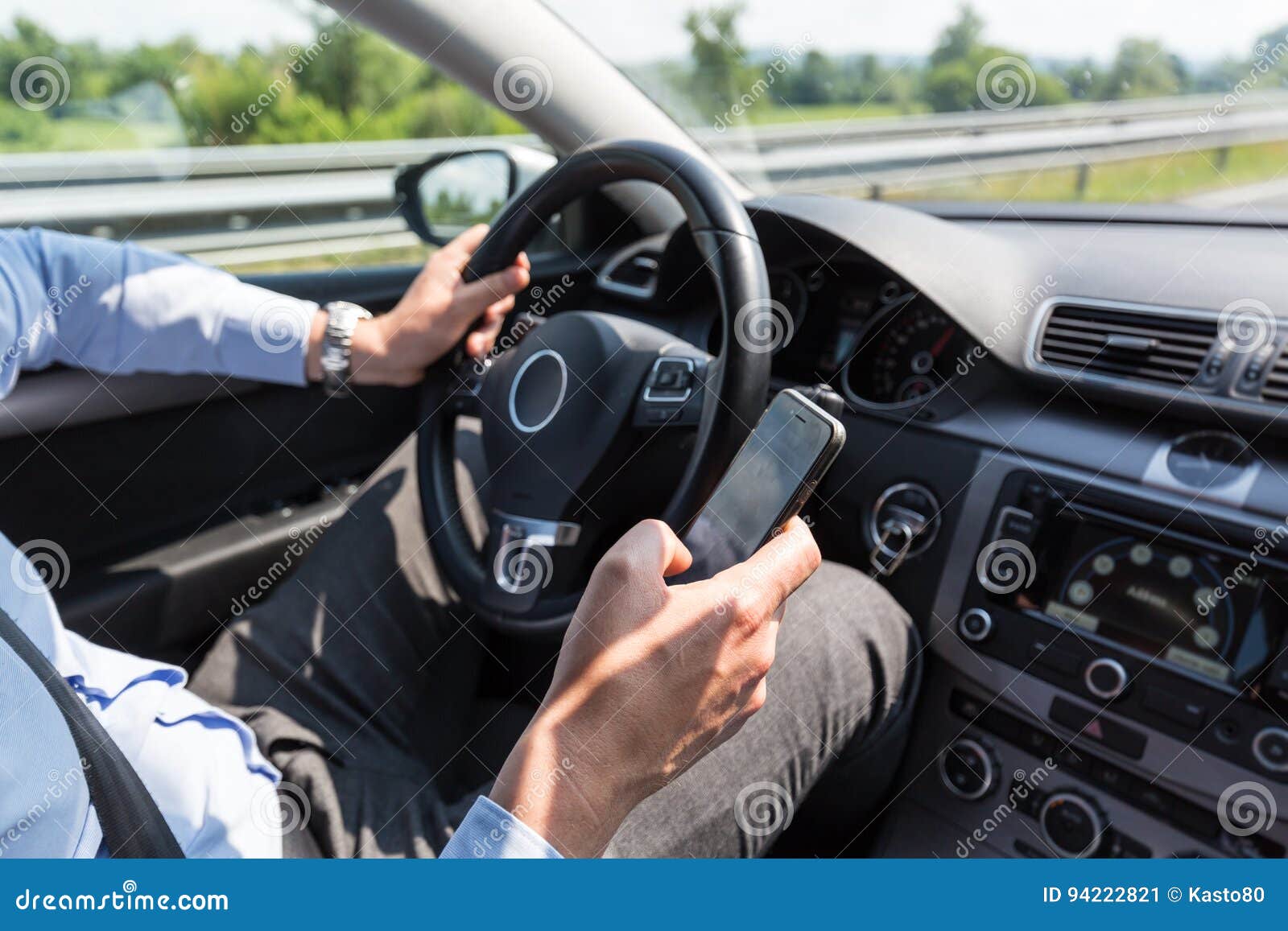 businessman texting on his mobile phone while driving.