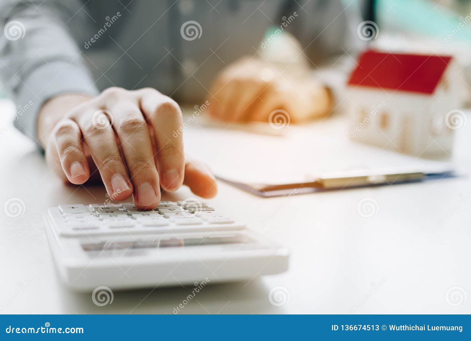 businessman using calculator calculate budget about house contract mortgage in the office room