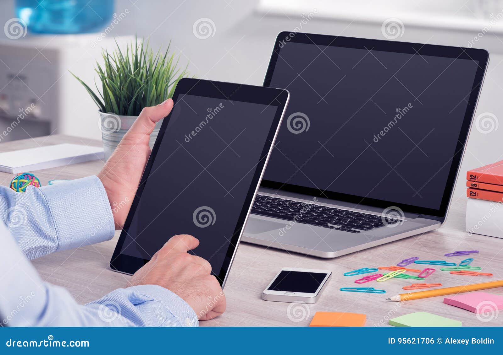 businessman using ipad digital tablet pc and macbook laptop on the office desk
