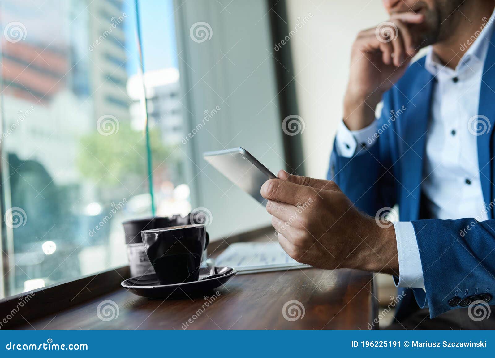 businessman using a tablet over coffee in a cafe