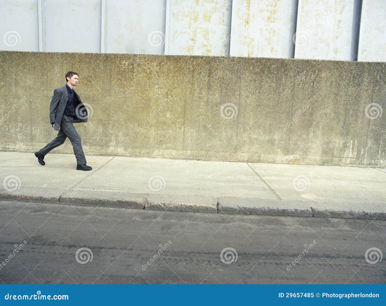 businessman walking on sidewalk