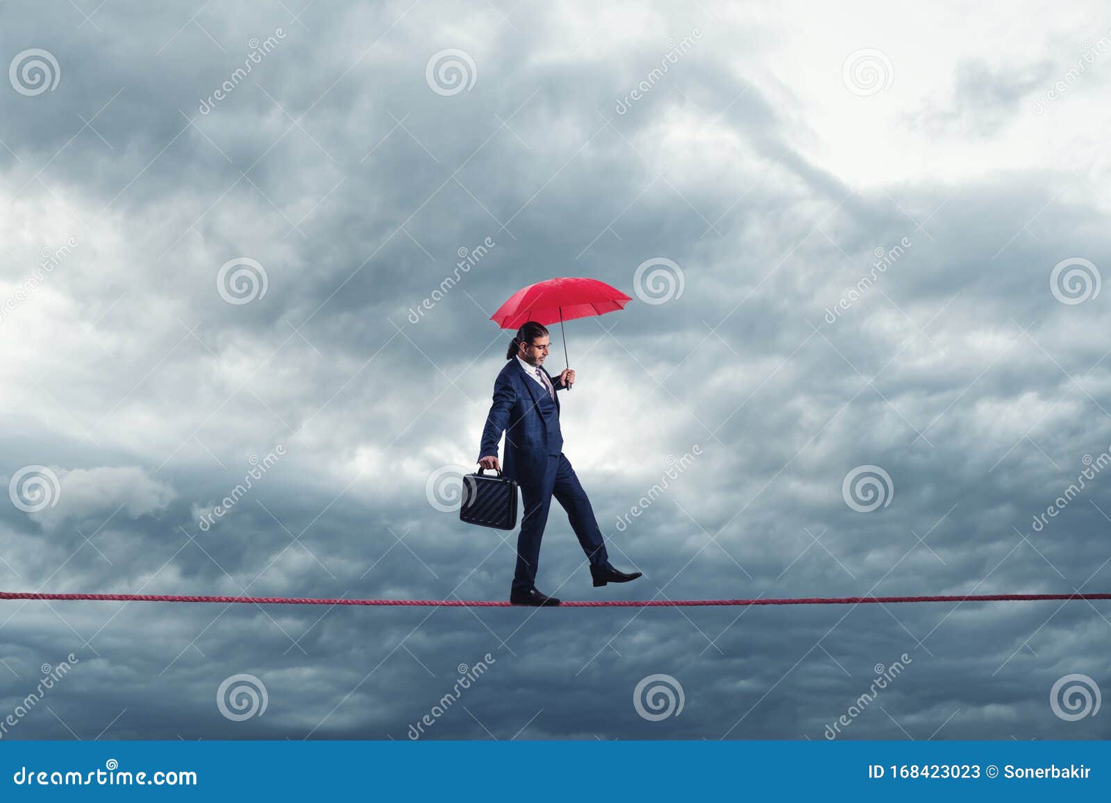 businessman is walking on a thiny rope, metaphoring risky business life an capability of solving problems in balance.