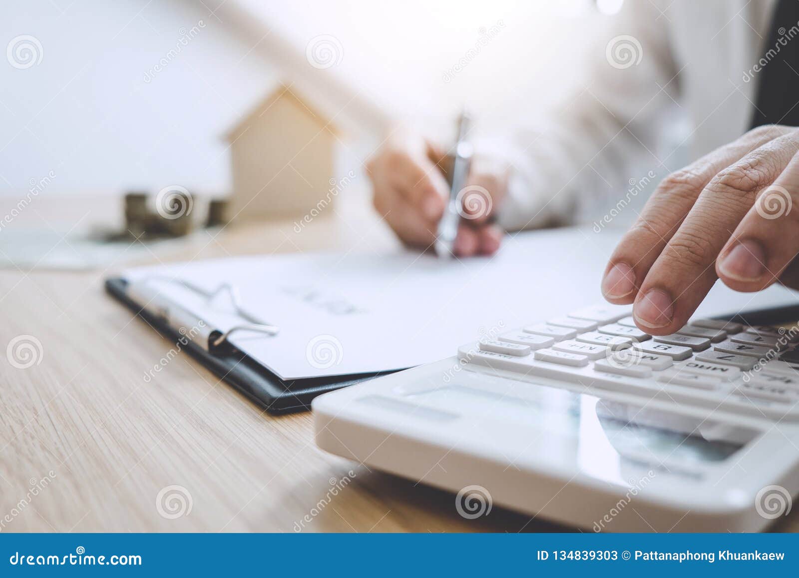businessman working doing finances and calculation cost of real estate investment while be signing to contract, concept mortgage