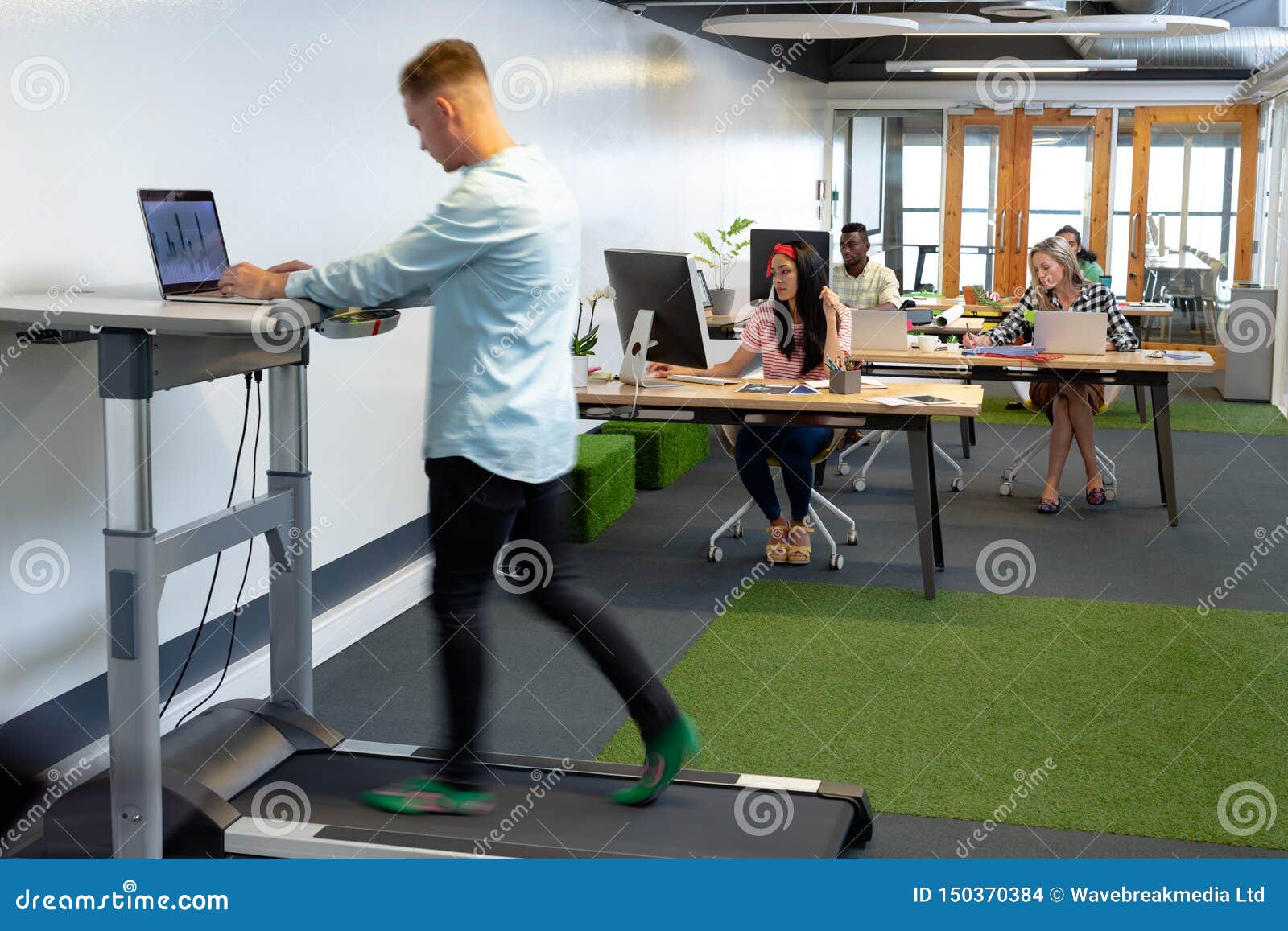 Businessman Working On Laptop While Exercising On Treadmill In A