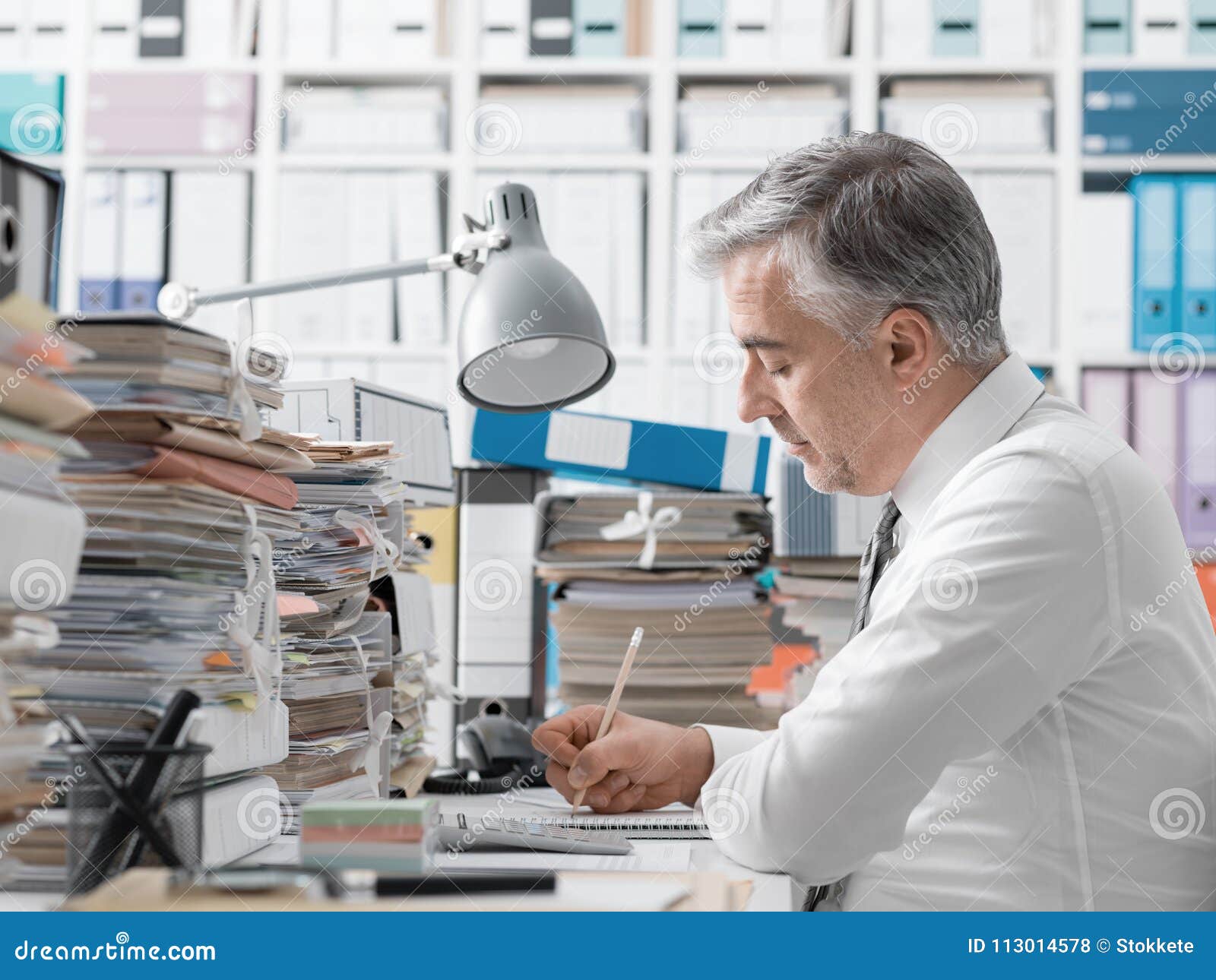 businessman working in the office and piles of paperwork