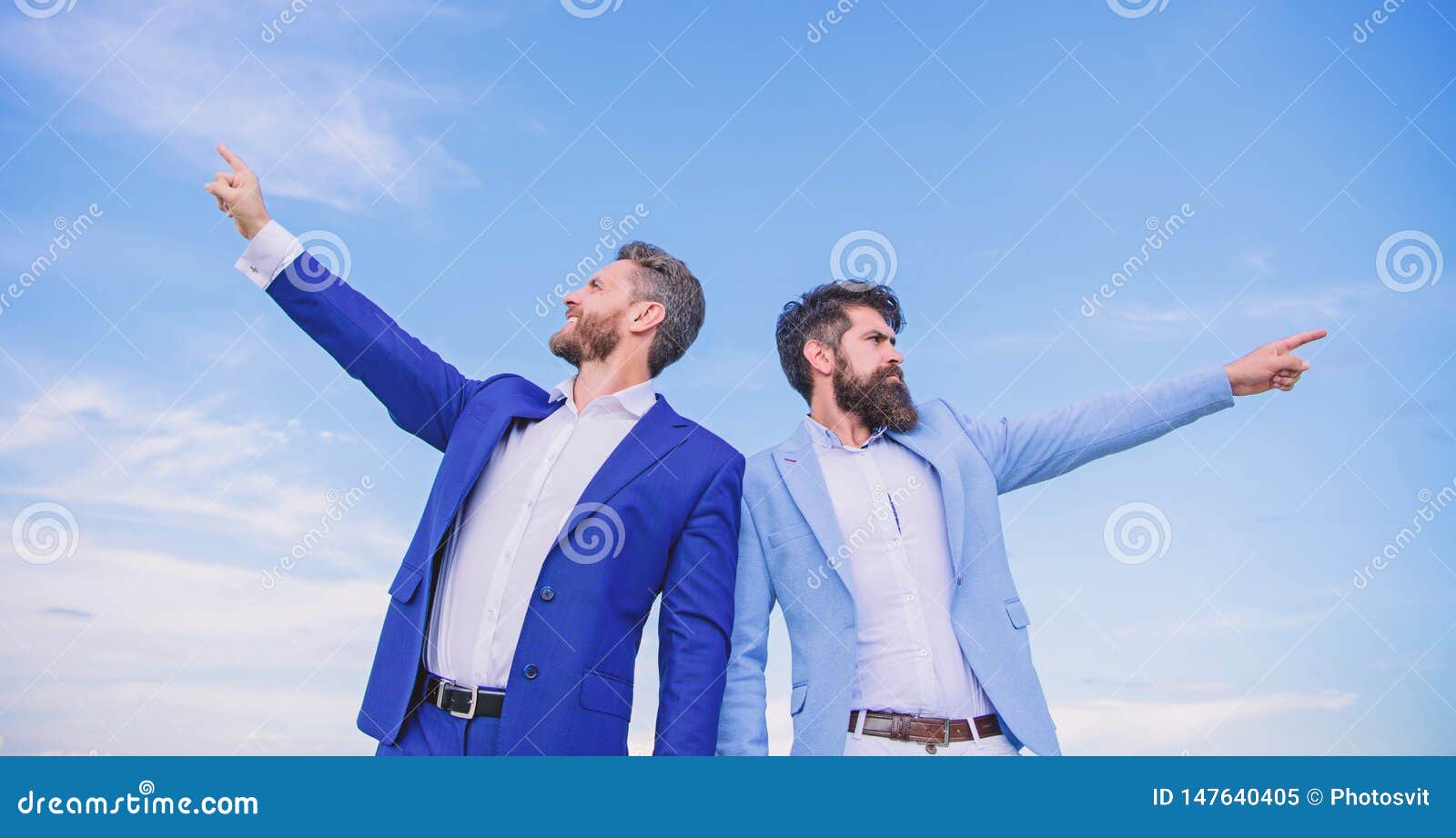 businessmen bearded faces stand back to back sky background. men formal suit managers pointing at opposite directions