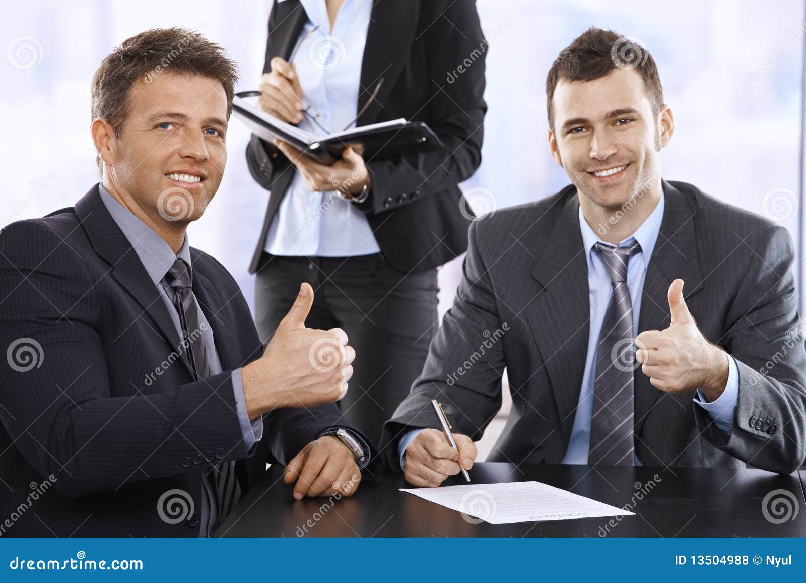 businessmen giving the thumbs up, smiling