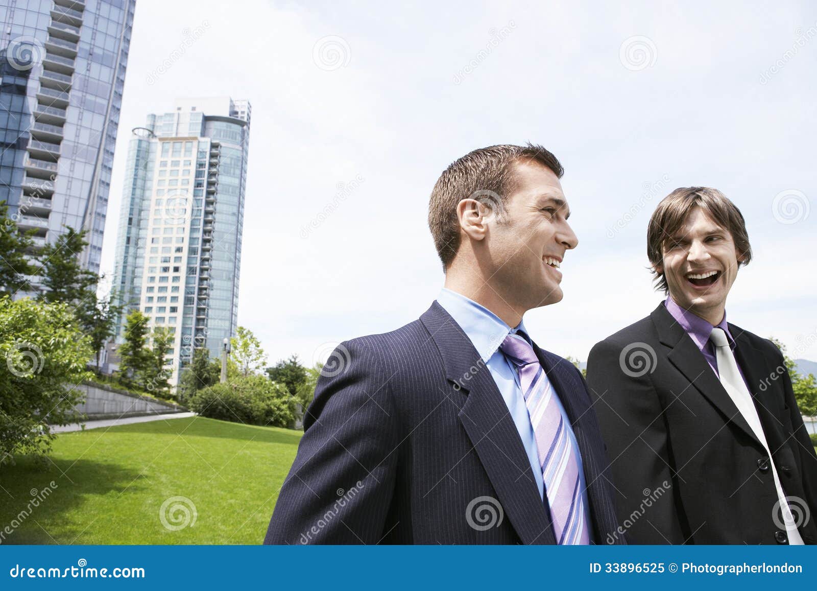 businessmen laughing by office buildings