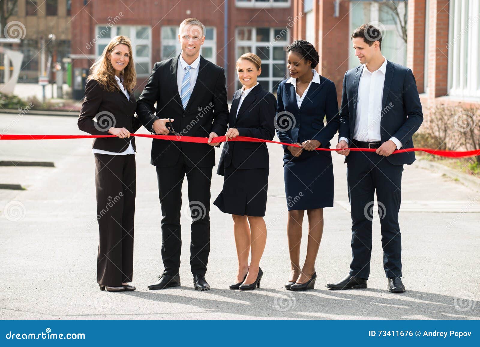 businesspeople cutting ribbon