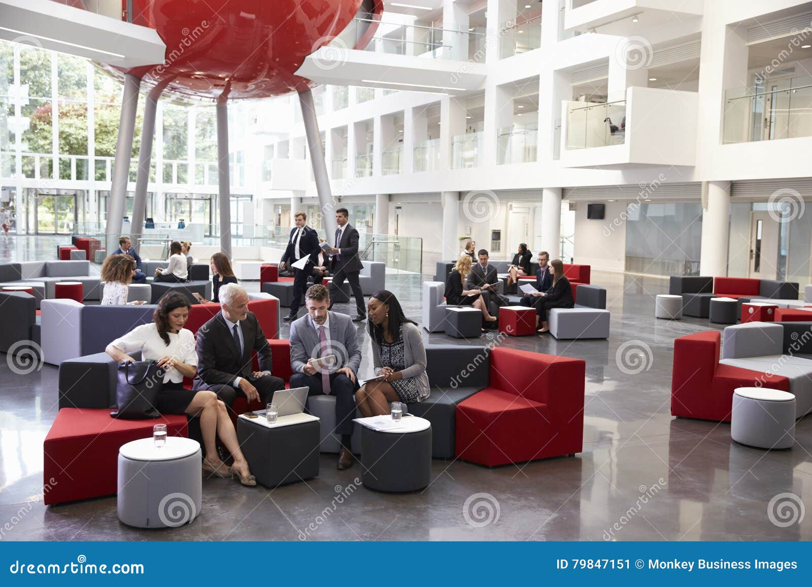 businesspeople meeting in busy lobby of modern office