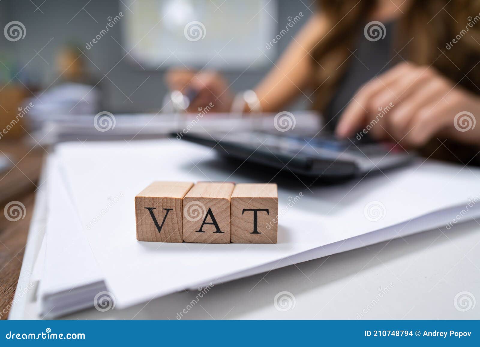 businessperson`s hand calculating vat with calculator