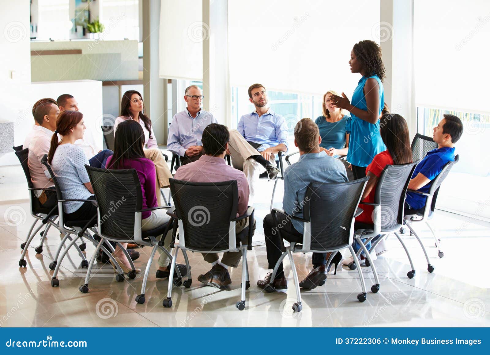 businesswoman addressing multi-cultural office staff meeting