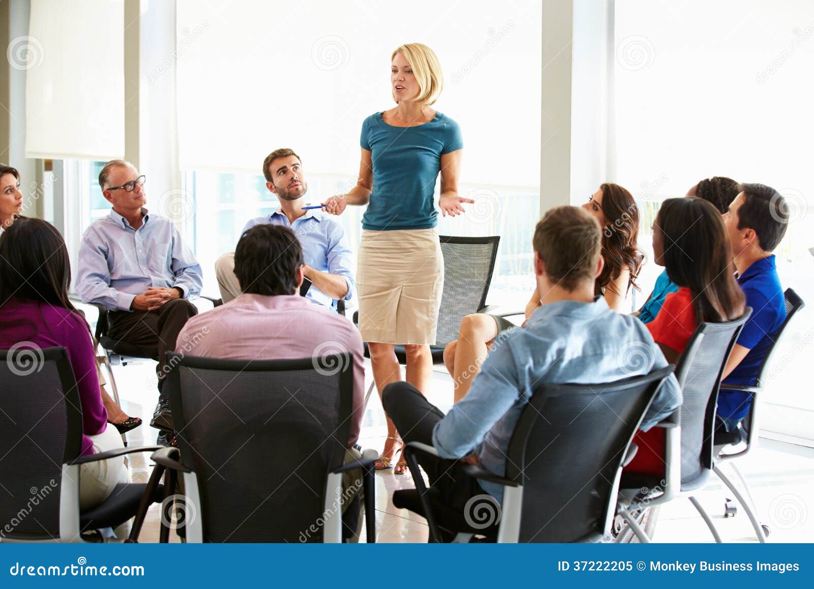 businesswoman addressing multi-cultural office staff meeting