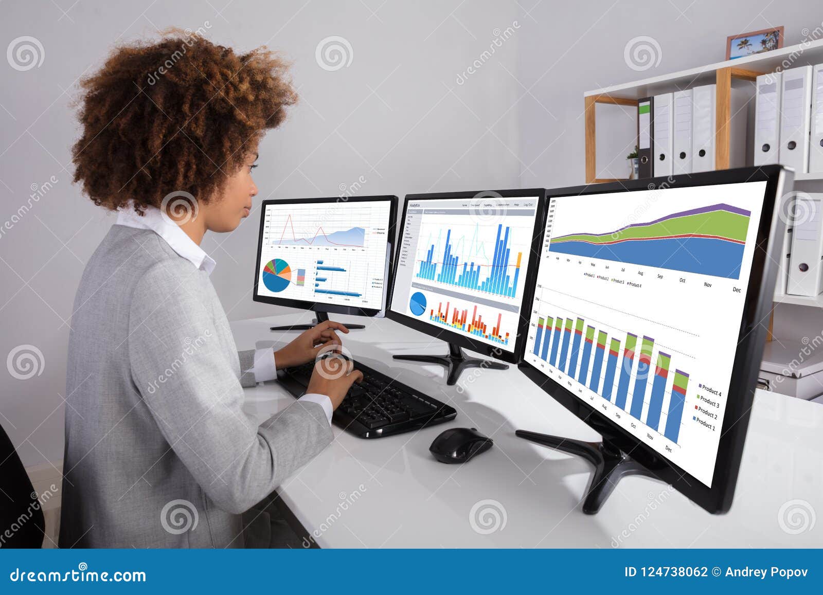 Businesswoman Analyzing Graph On Multiple Computers Stock Photo