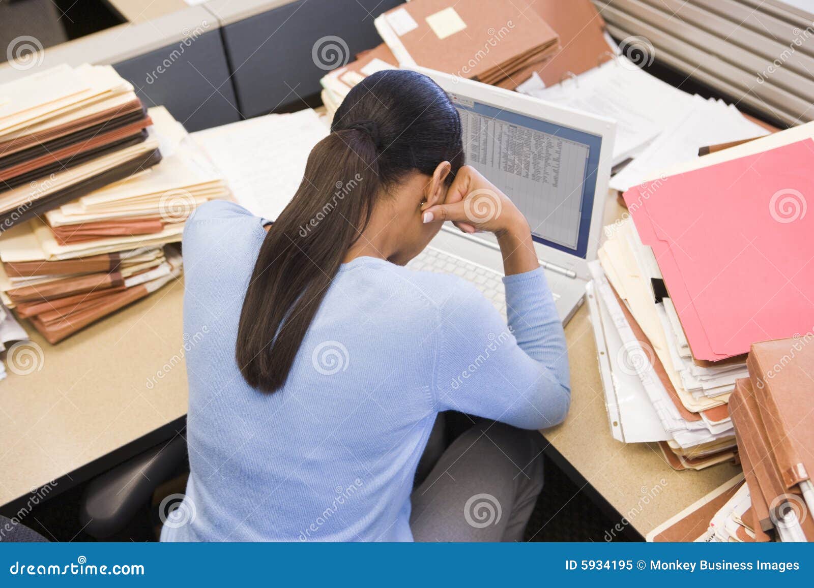 businesswoman in cubicle with laptop