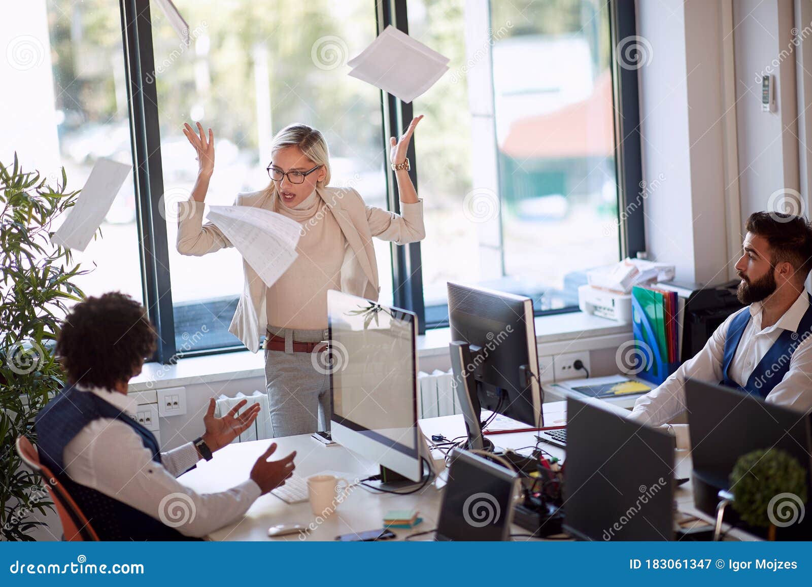 businesswoman getting angry at a coworker. businesswoman throwing the papers in rage