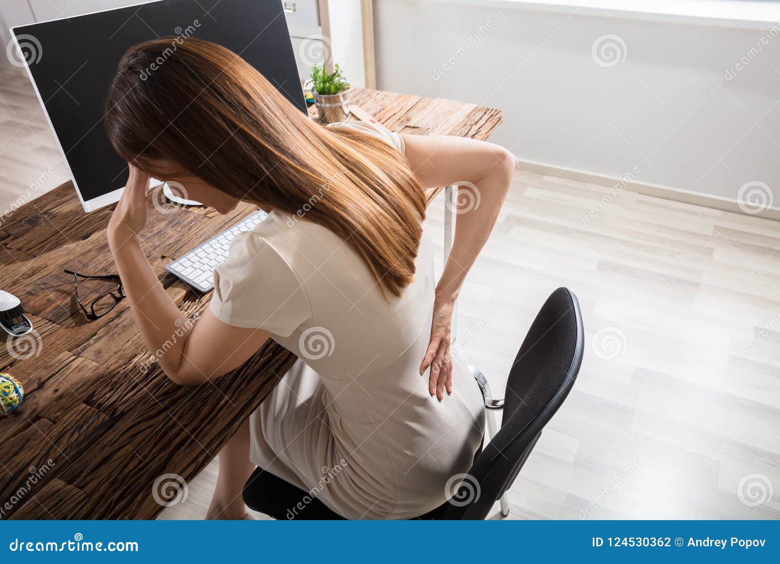 businesswoman having back pain at workplace