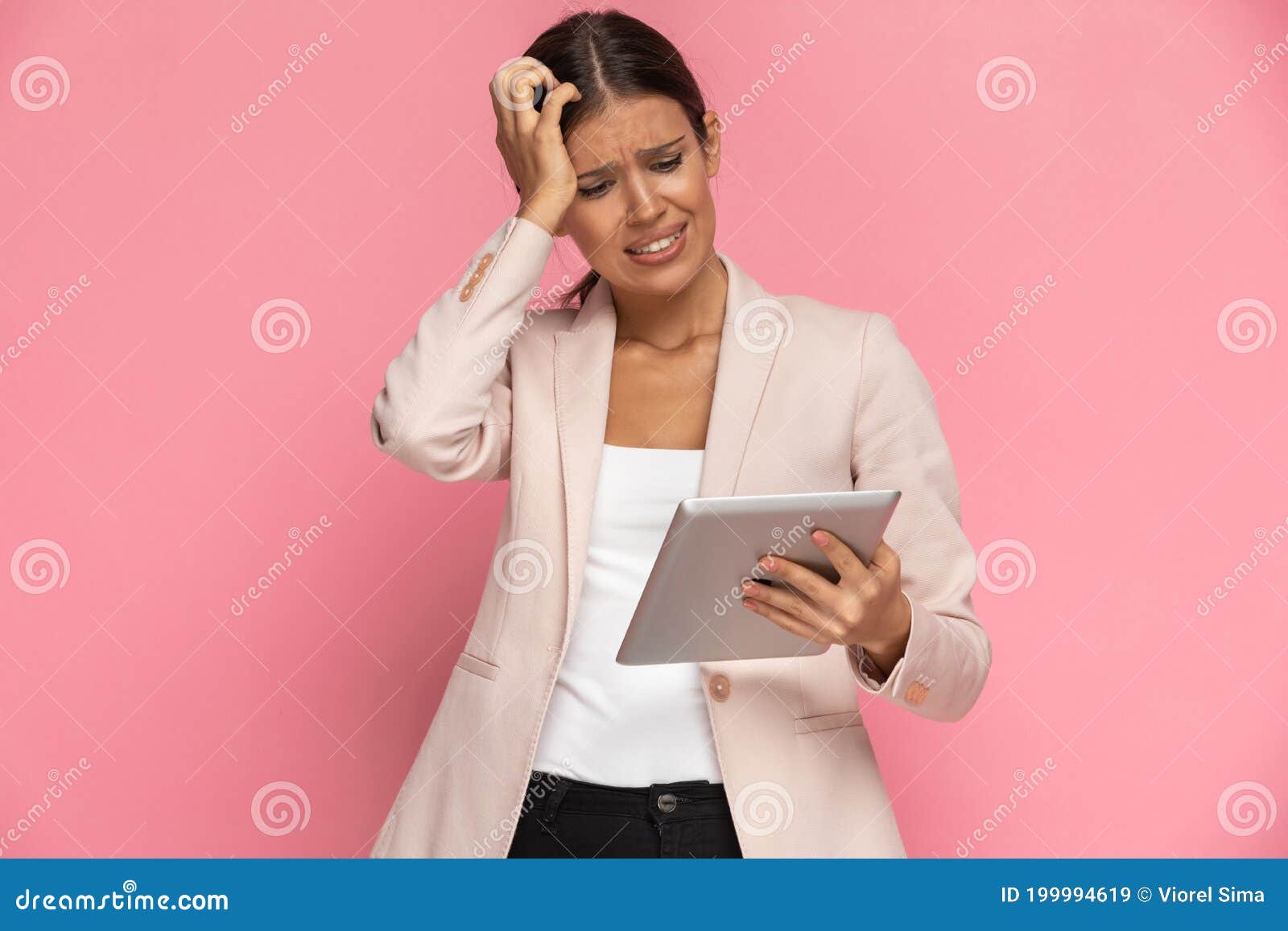 businesswoman looking at her tablet and feeling panicked
