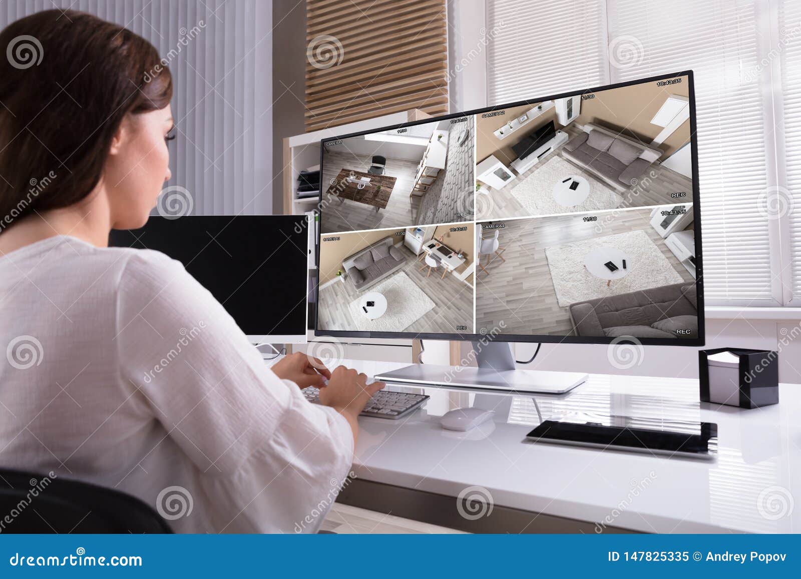 businesswoman monitoring cctv footage on computer