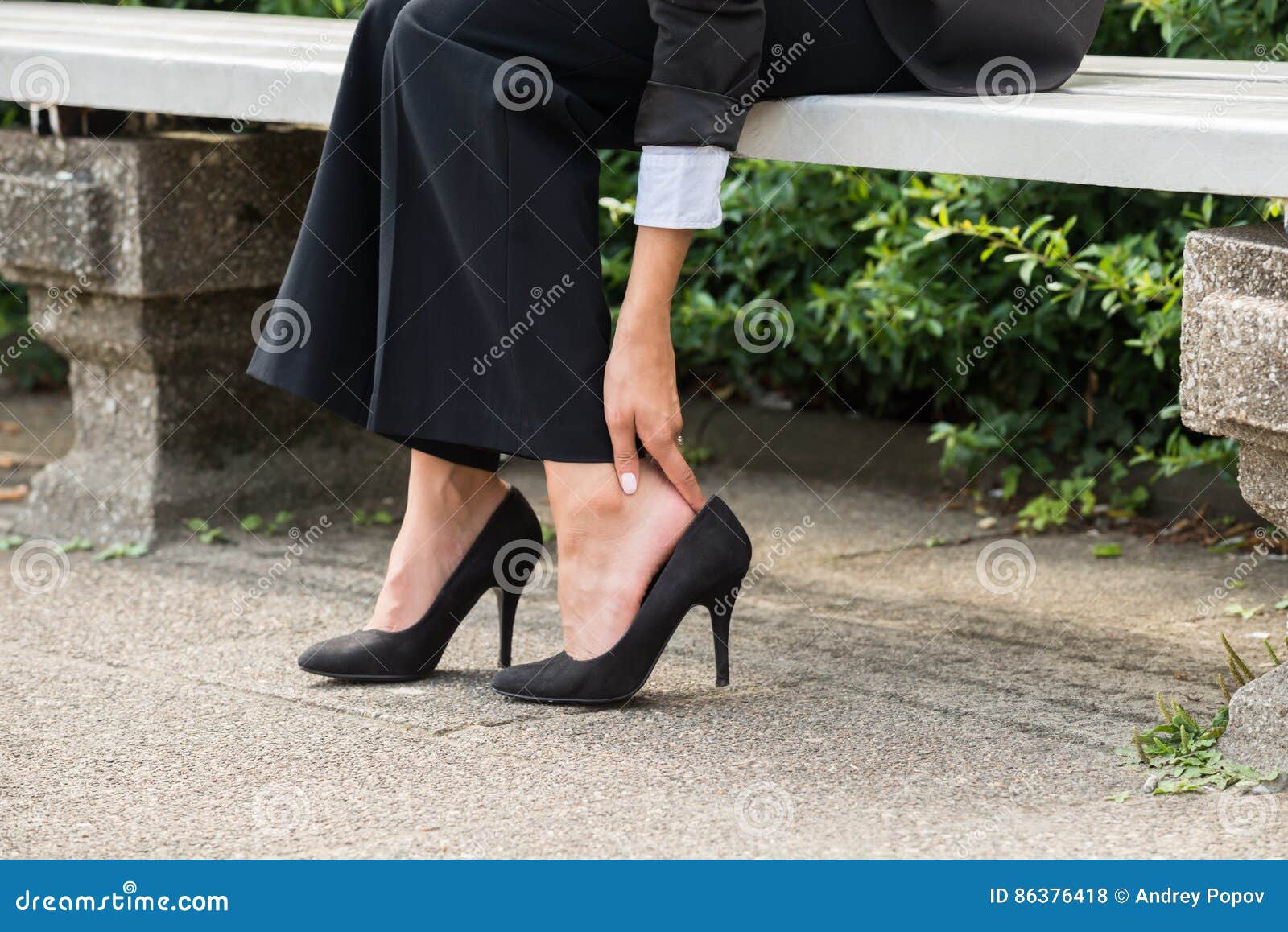 businesswoman`s hand removing high heels