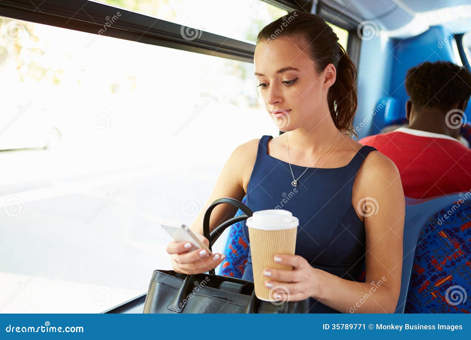 businesswoman sending text message on bus