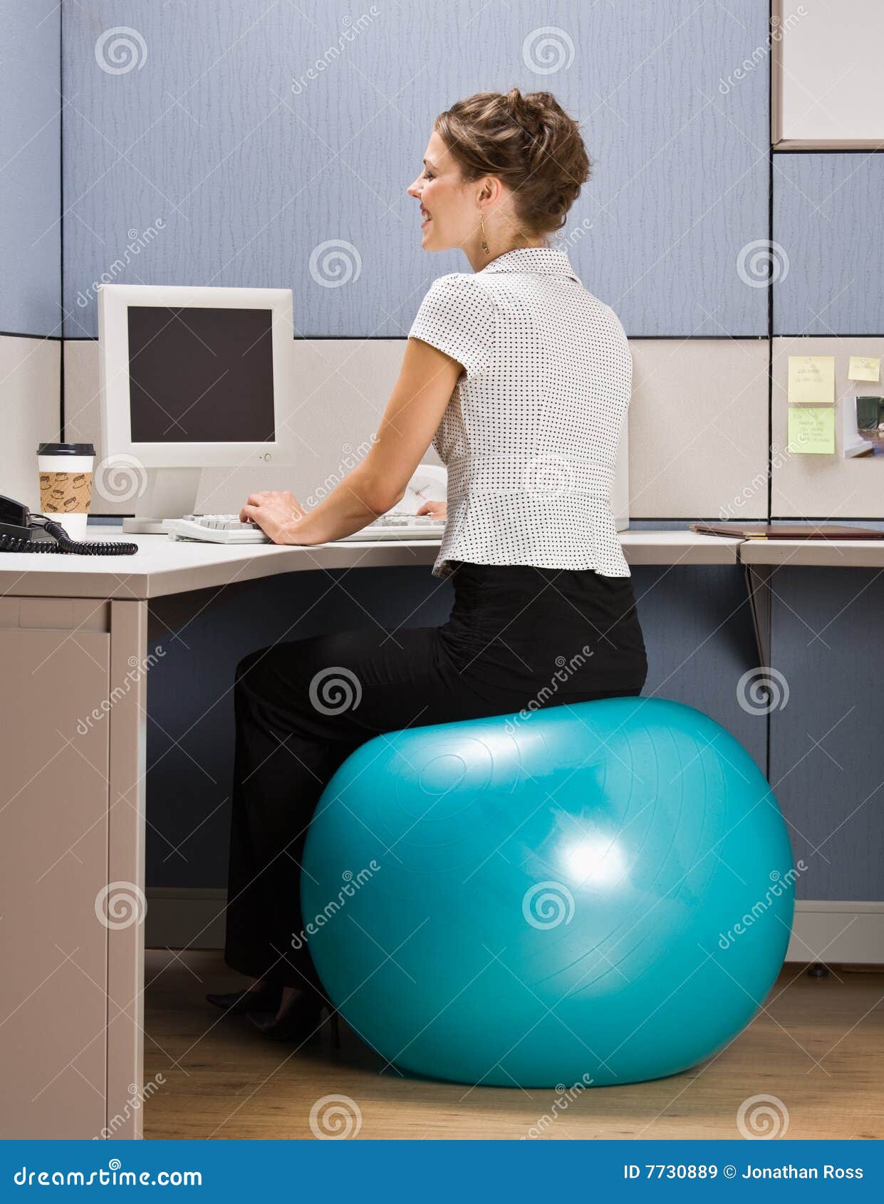 businesswoman sitting on exercise ball at desk