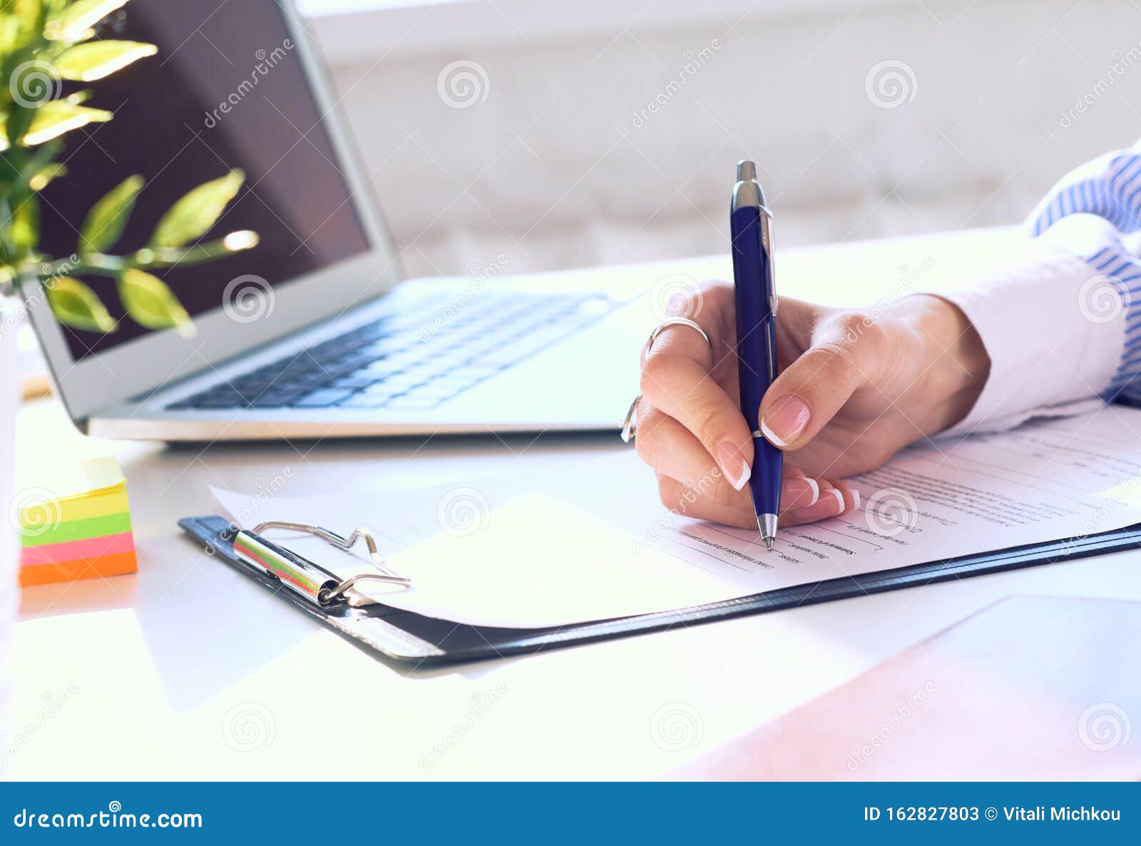 Businesswoman Sitting at Office Desk Signing a Contract or Making Notes ...