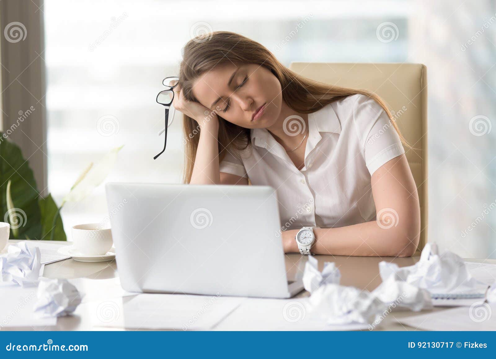 businesswoman sleeping with head on hand at work