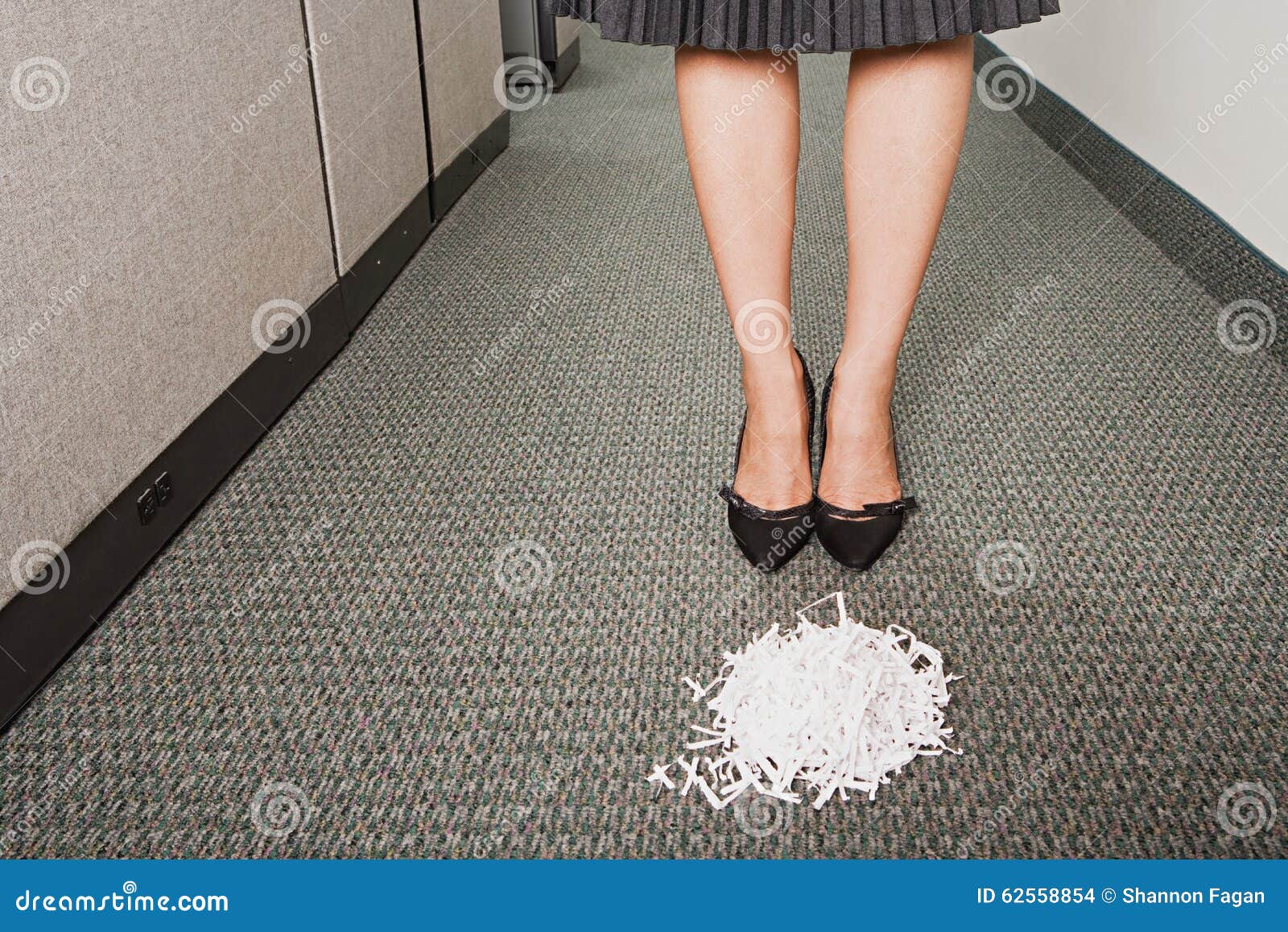 businesswoman stood in front of pile of paper shreddings