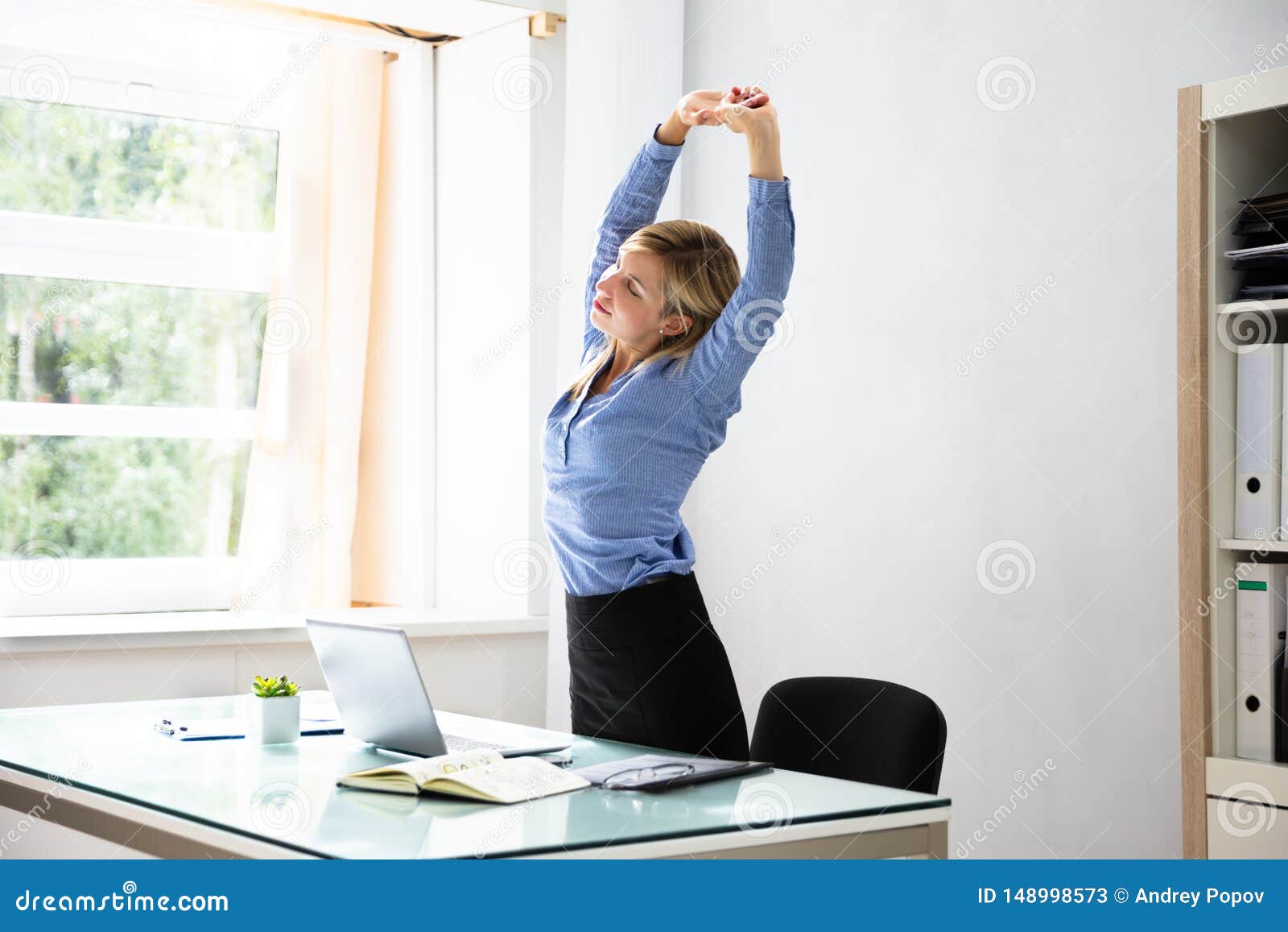 businesswoman stretching her arms at workplace
