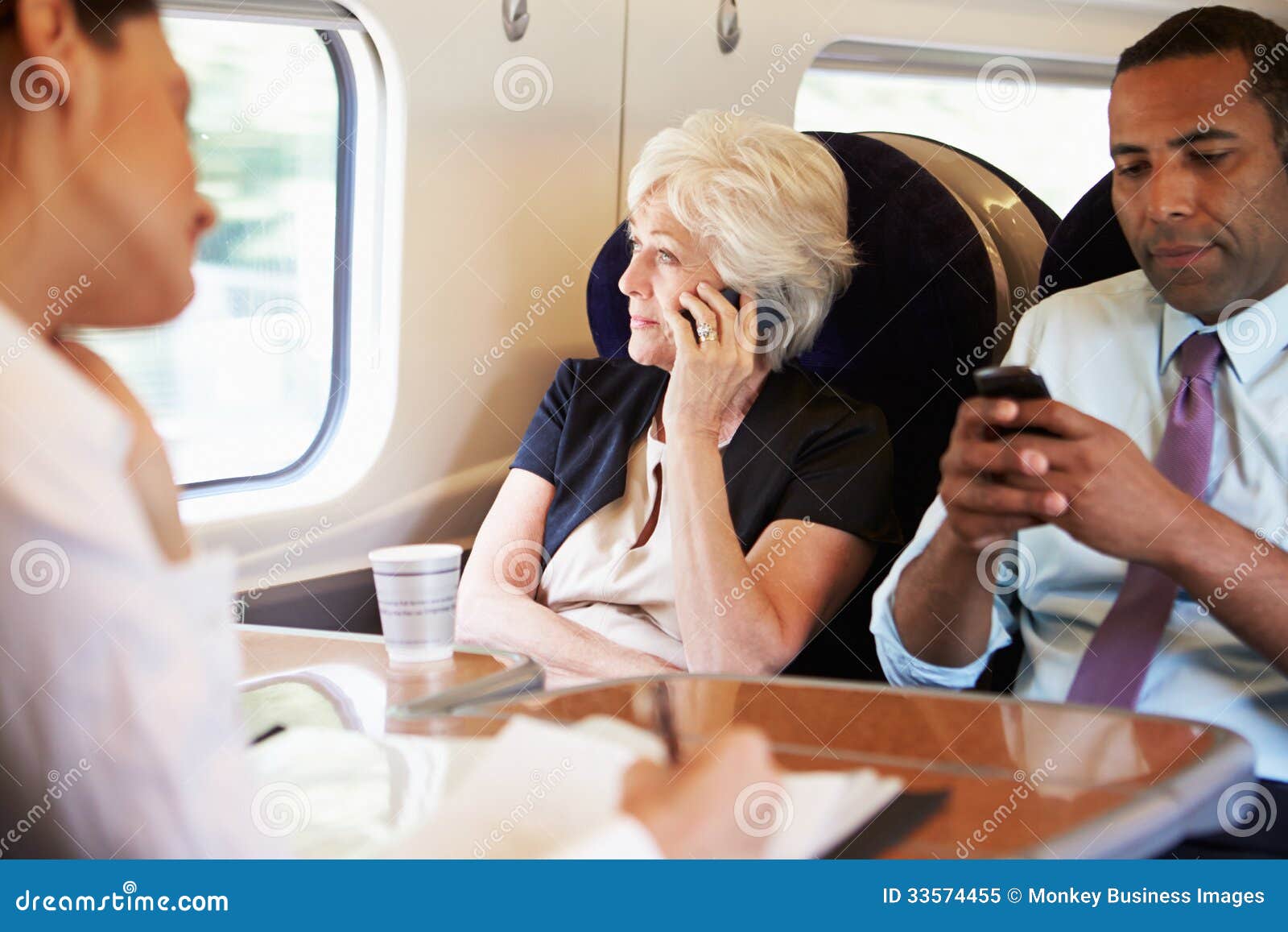 businesswoman using mobile phone on busy commuter train