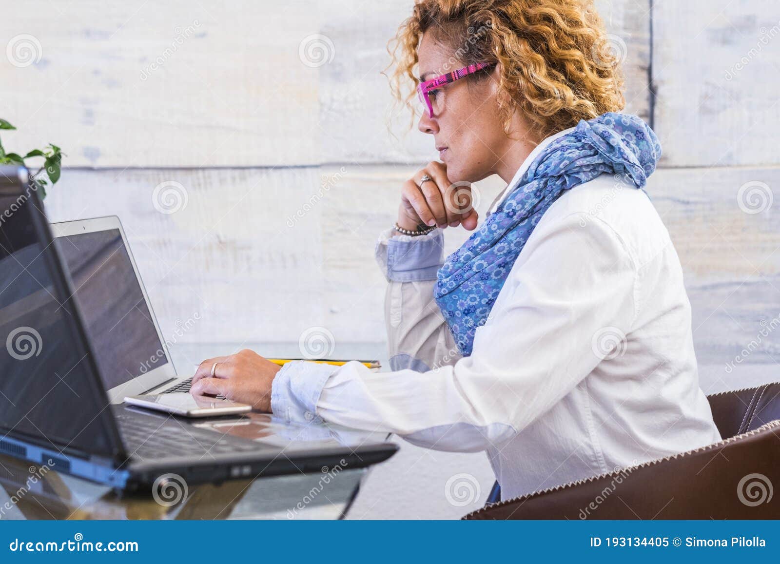 businesswoman at work in a workplace indoor home place - woman working with two personal laptop computer - concept of office and