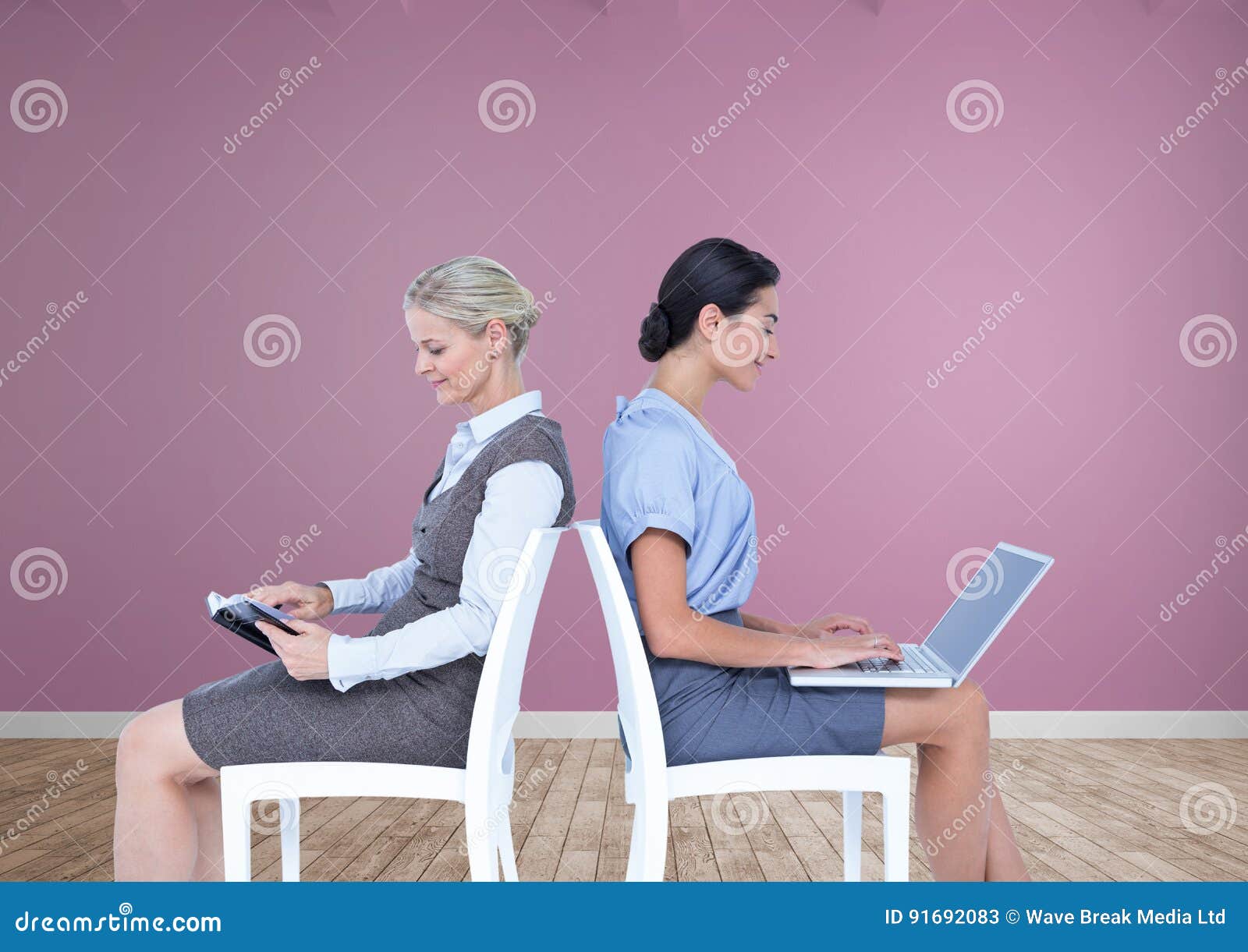 Businesswomen Collaborating Working Back To Back on Chairs Stock Image