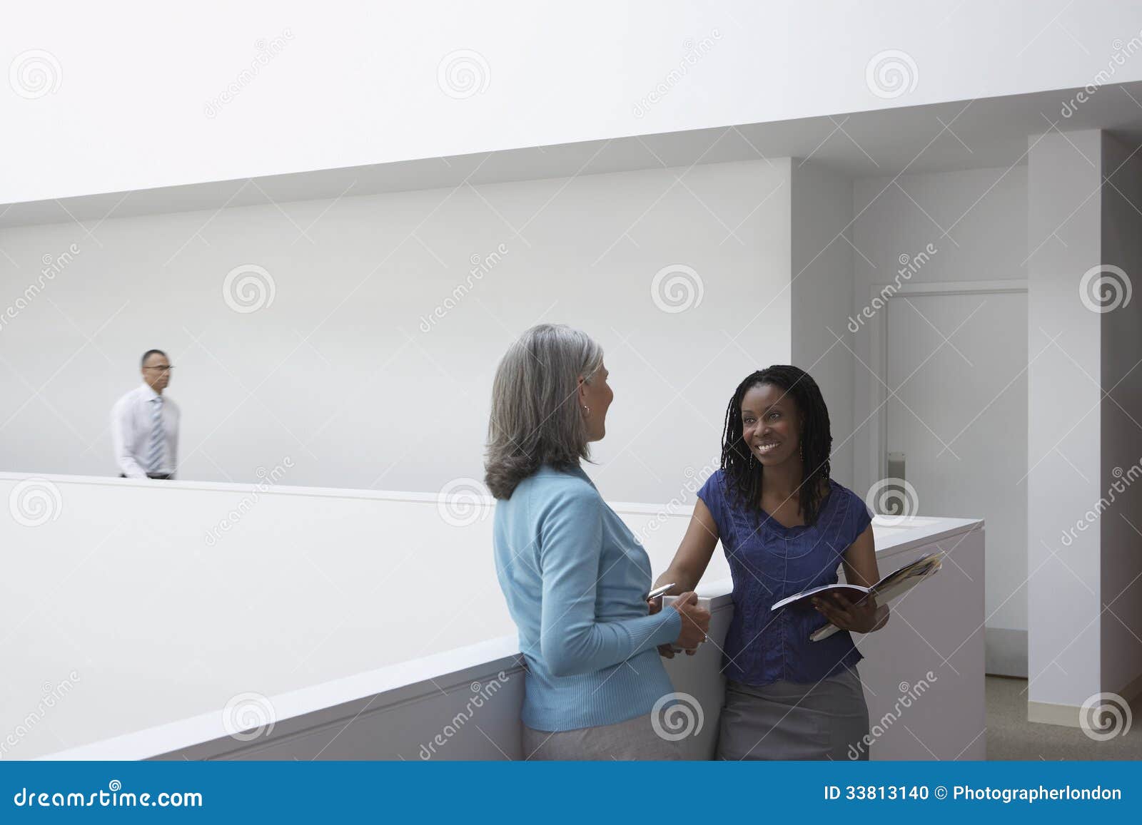 businesswomen talking in office hallway