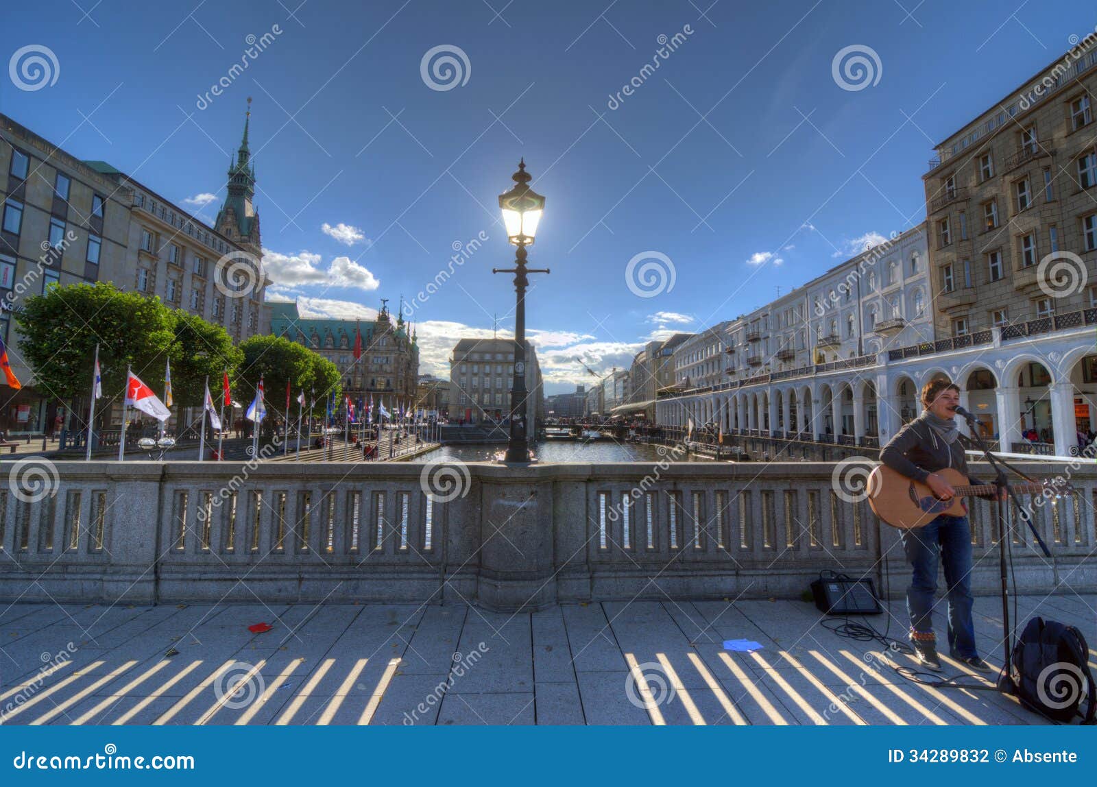 Busker. Hamburgo. HAMBURGO, ALEMANHA - 26 DE SETEMBRO: Um músico da rua joga a guitarra em uma ponte sobre o canal “Kleine Alster” o 26 de setembro de 2013 em Hamburgo, Alemanha