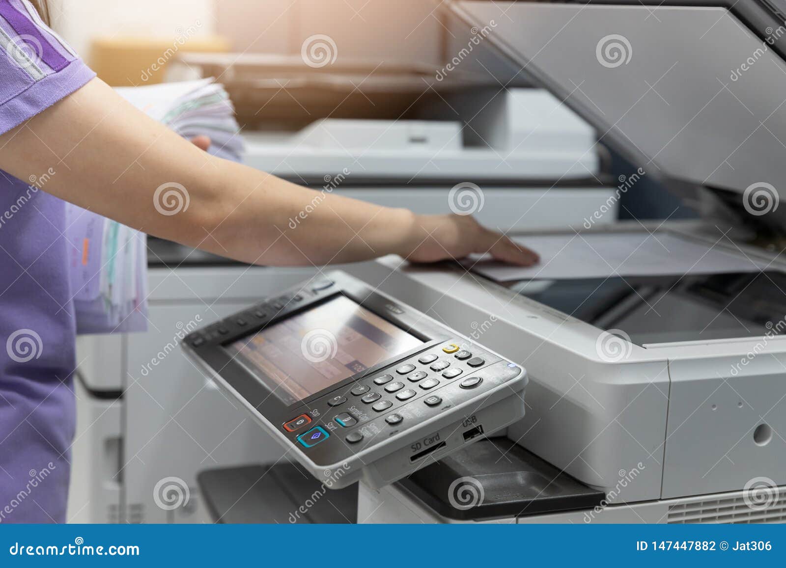 bussinesswoman using copier machine to copy heap of paperwork in office