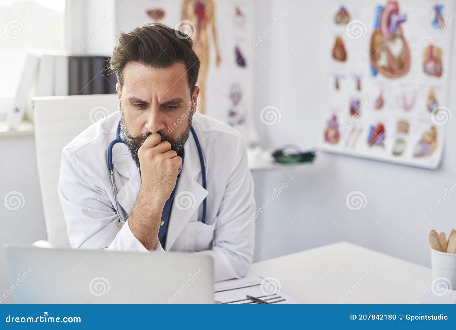 busy doctor working with laptop in doctorÃ¢â¬â¢s office