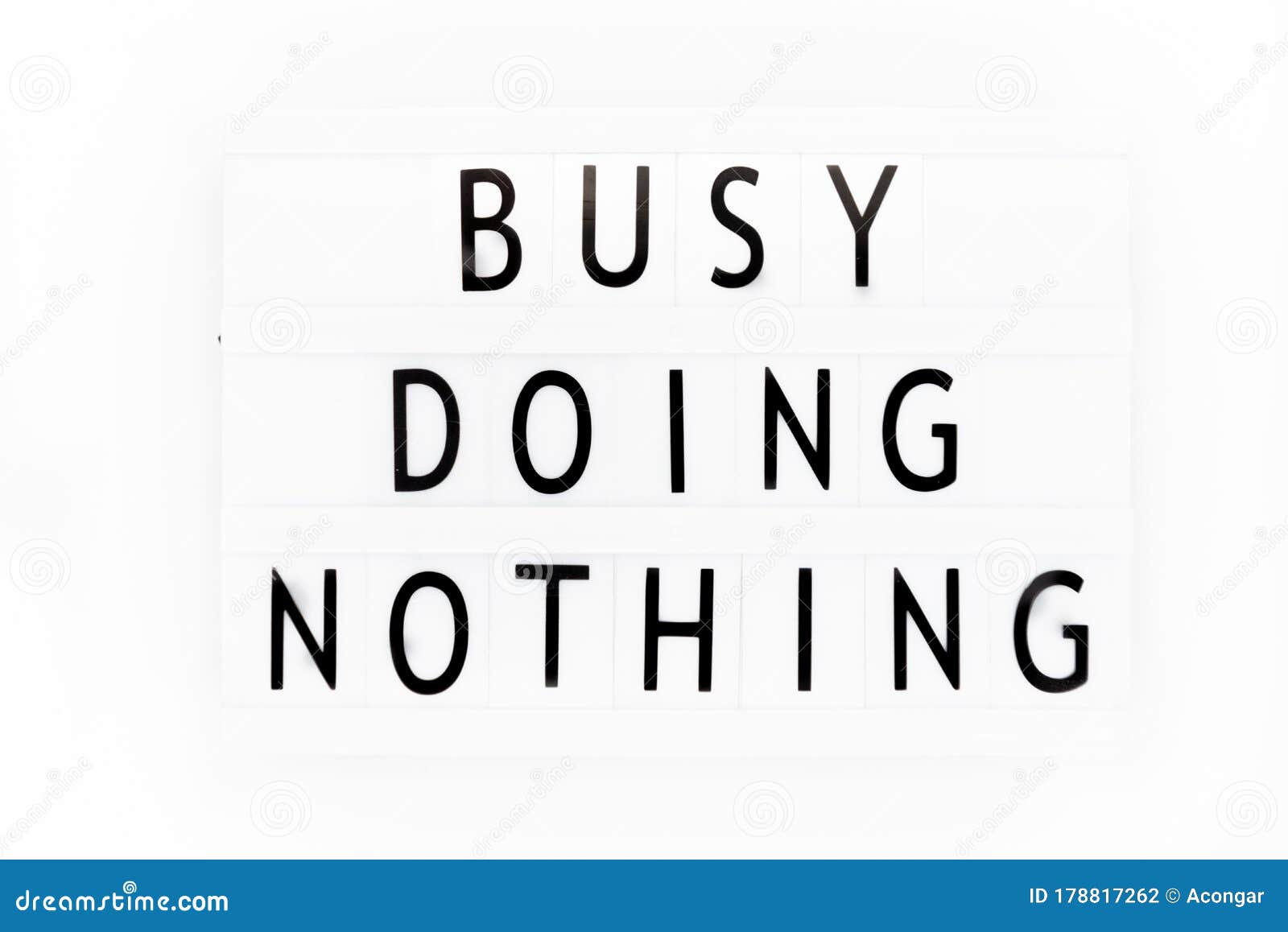 Busy Doing Nothing, Inspirational Text Written on a Light Box Stock