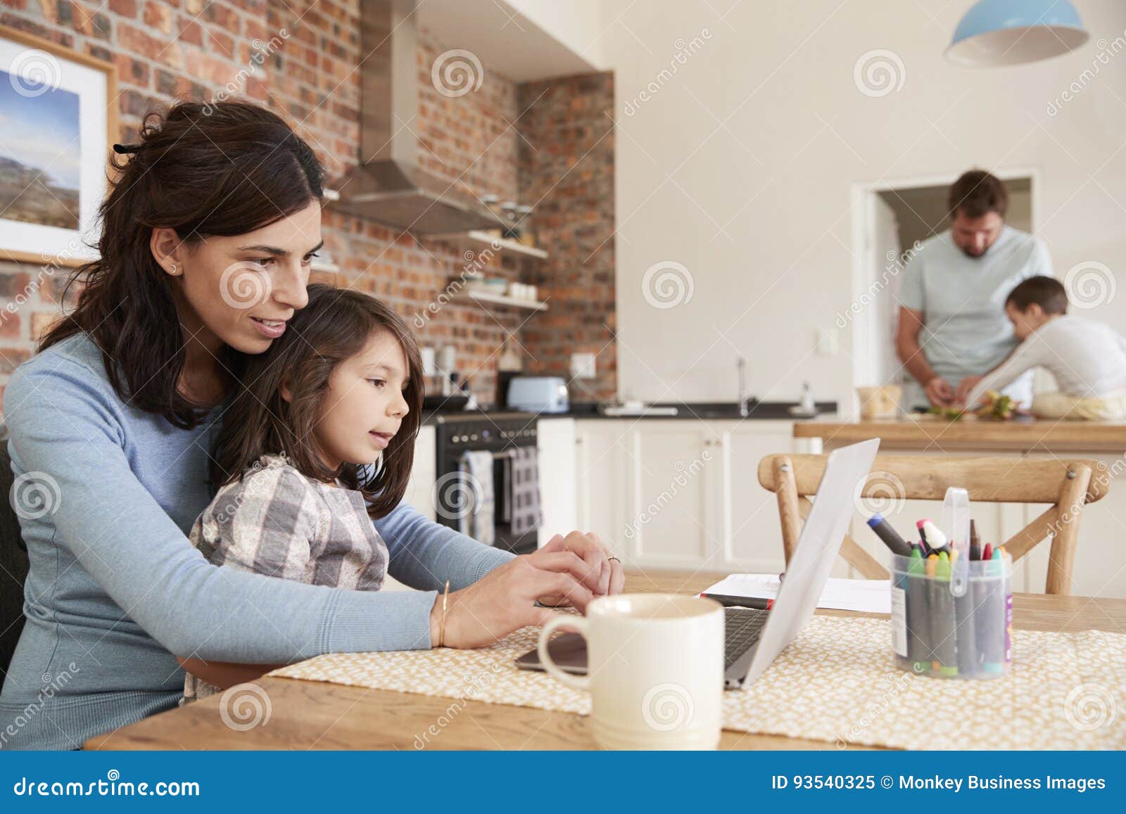 busy family home with mother working as father prepares meal