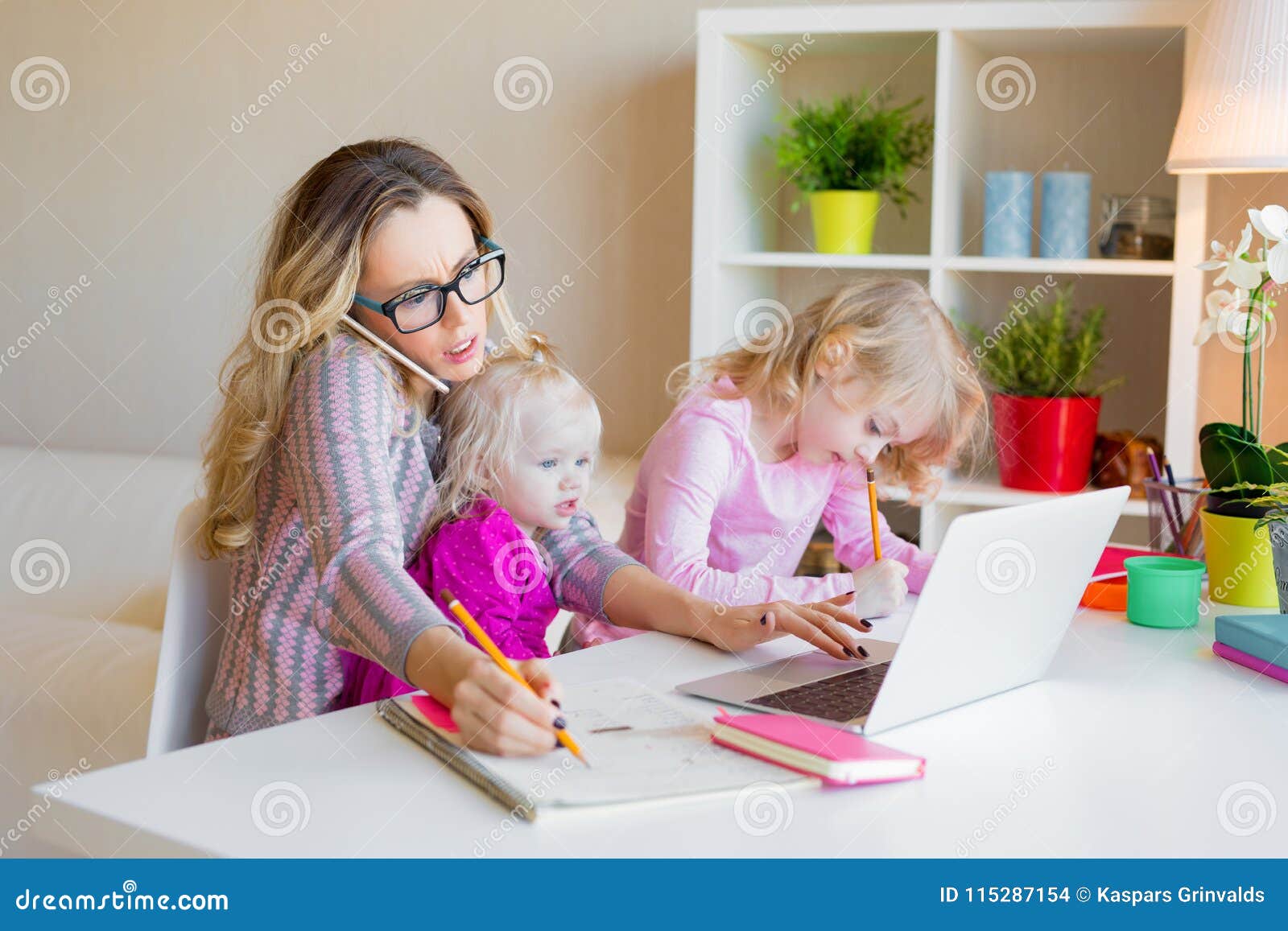 busy woman trying to work while babysitting two kids