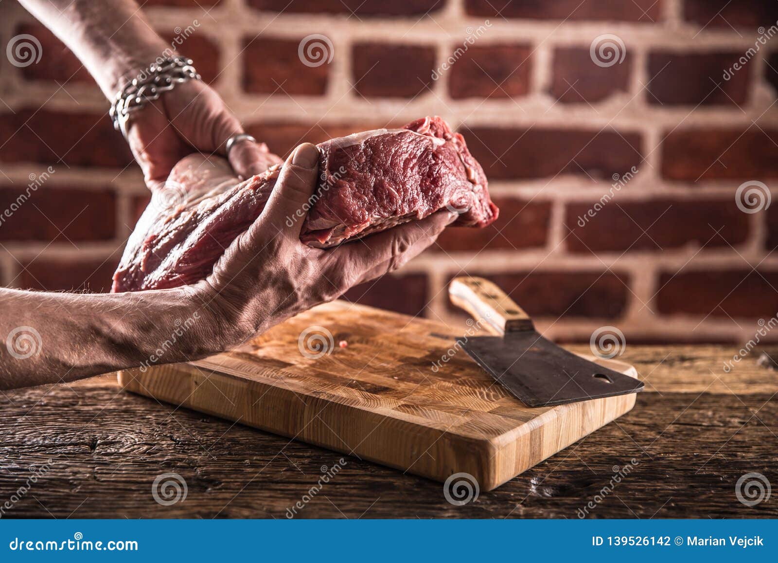 Butcher Man Hands Holding Raw Beef Steak in Butchery Stock Photo
