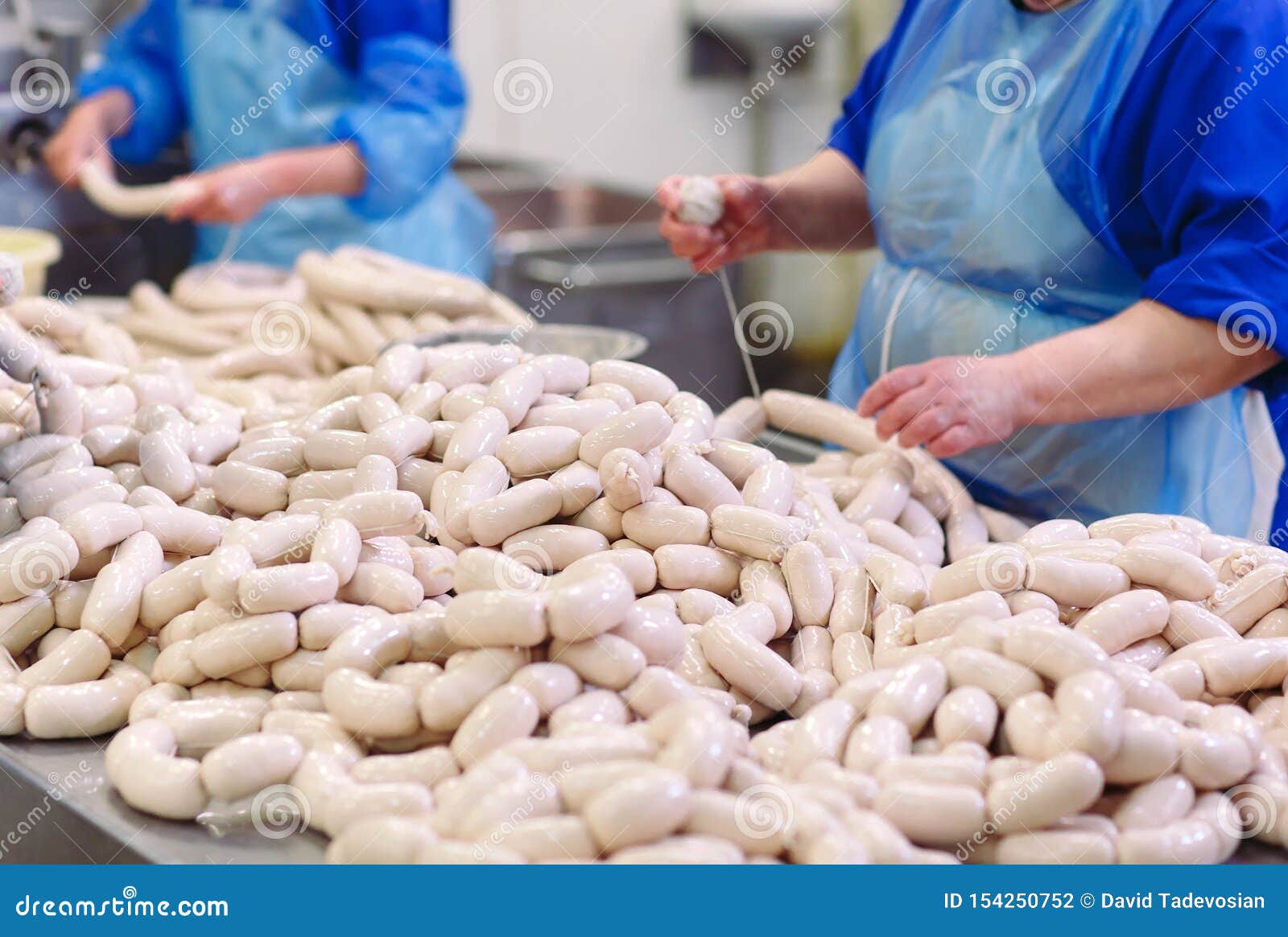 Butchers Processing Sausages at a Meat Factory. Stock Photo Image of