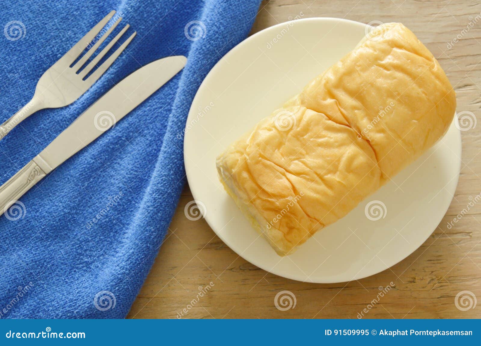 Butter Bread Loaf on White Dish with Table Knife and Fork Stock Image