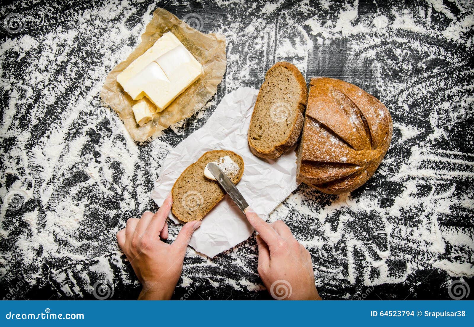 The Buttering of Bread with Butter on Board with Flour. Stock Photo