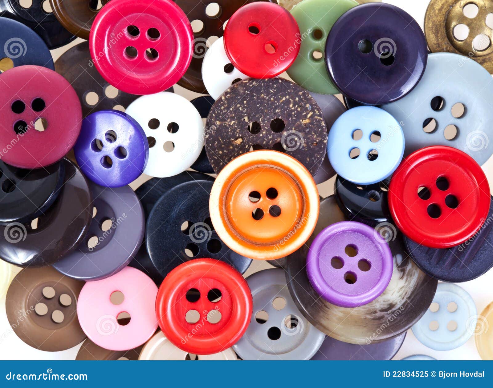 A pile of colorful buttons on a white surface. Buttons colored
