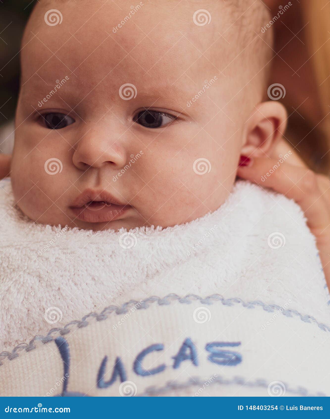 Close-up of a three-month-old baby with a bib and before starting to eat