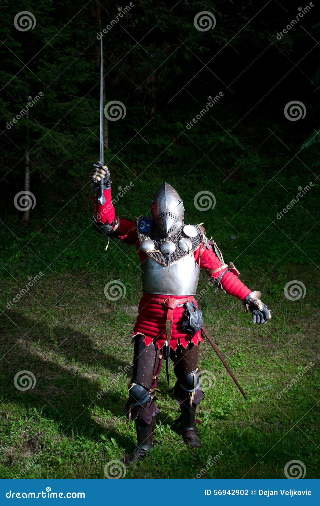 Caballero medieval With Sword en mano aumentada en el bosque en la noche, fondo verde